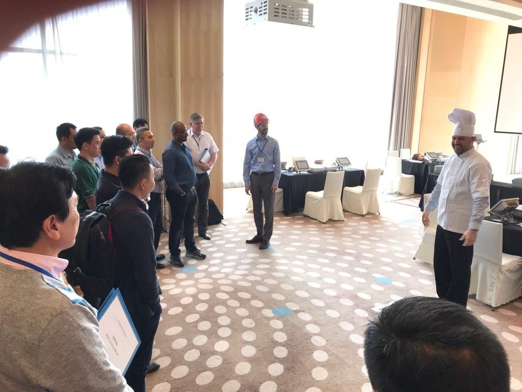 Andrew in a chef's uniform running a hands-on demo for sales leaders